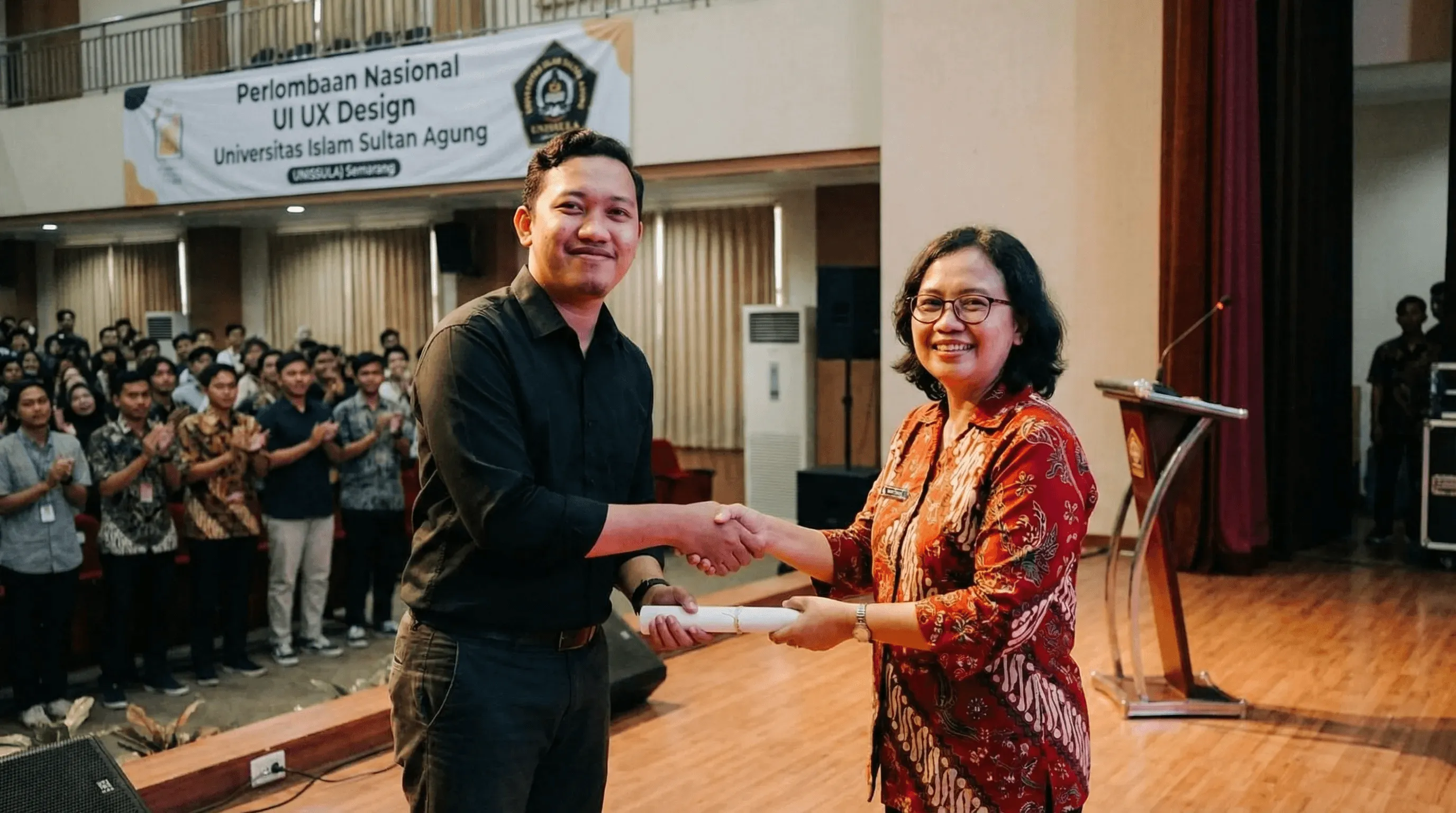 person discussing while standing in front of a large screen in front of people inside dim-lighted room